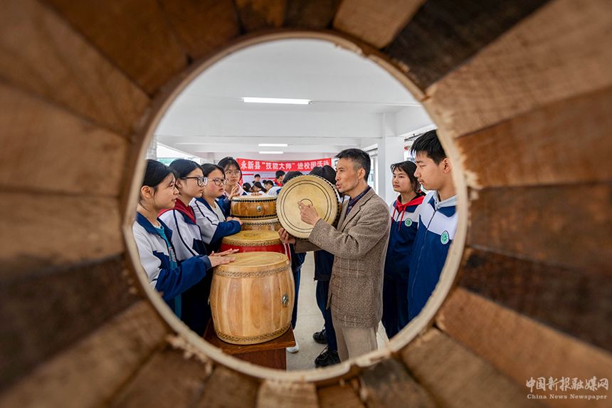 近日，江西省吉安市永新縣開展技能大師進(jìn)校園活動。當(dāng)?shù)刂乒募寄艽髱熢诮o孩子們傳授制鼓技藝。王惠民攝